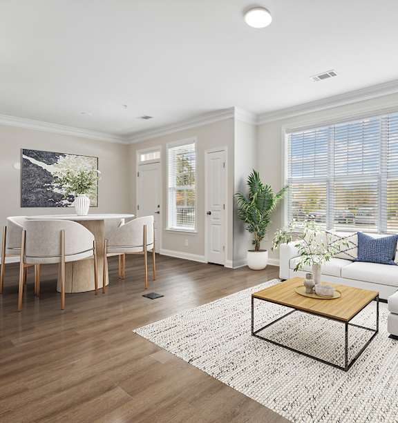 A living room with a sofa, a coffee table, a painting, a ceiling fan, and a bedroom in the background.
