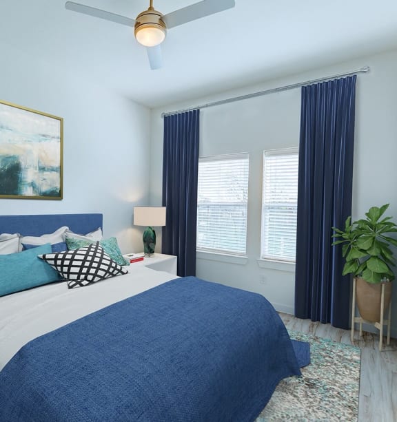 a blue and white bedroom with a bed and a ceiling fan