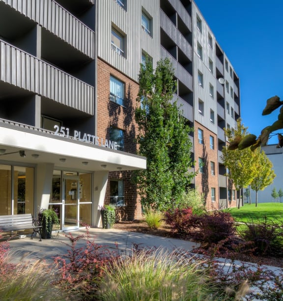 a large apartment building with balconies and a grassy area in front of it at Platts Crossing, London, ON