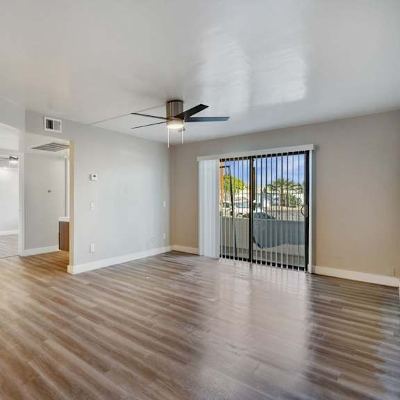 A spacious kitchen with white cabinets and a wooden floor.