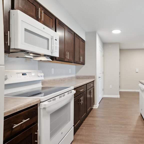 a kitchen with white appliances and wooden cabinets