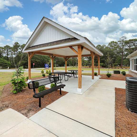 a picnic pavilion with benches and a grill