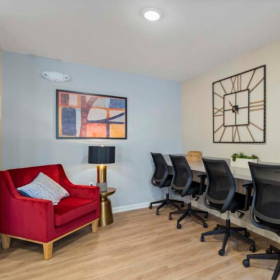 a conference room with a desk and chair and a red couch