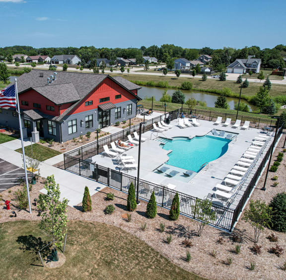 an aerial view of a swimming pool and building with a red house at Tivoli Green Apartments & Townhomes, Mount Pleasant, Wisconsin