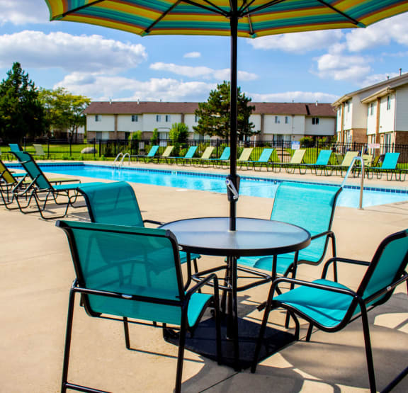 our apartments have a resort style pool with chairs and tables