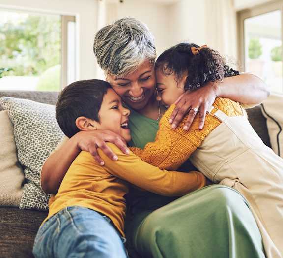 A woman and two children are sitting on a couch.
