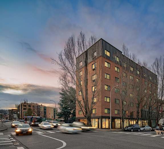 a tall brick building with a lot of windows and a street in front of it
