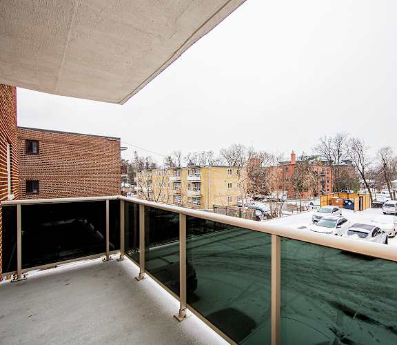 a balcony with a view of a parking lot and buildings in the distance