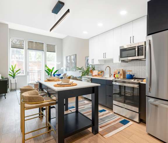 a kitchen with stainless steel appliances and a table with chairs