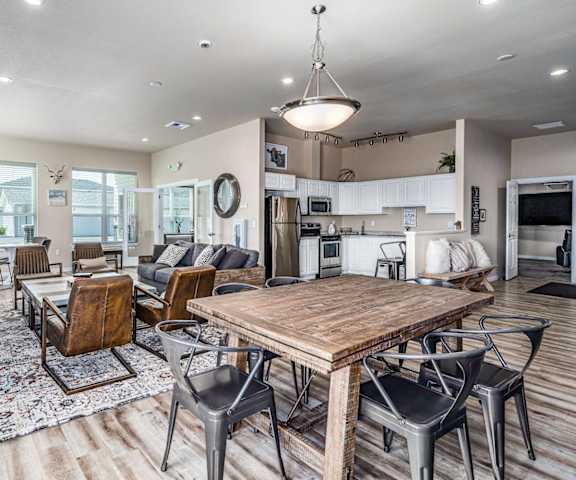 A modern open plan living and dining area with a wooden table and chairs.