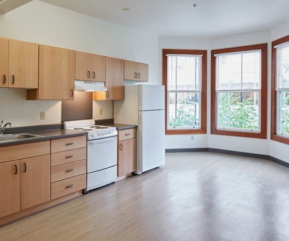 A kitchen with wooden cabinets and a white refrigerator.