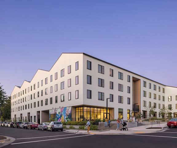 A modern building with a parking lot in front of it.