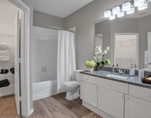 A bathroom with a toilet, sink, and mirror.