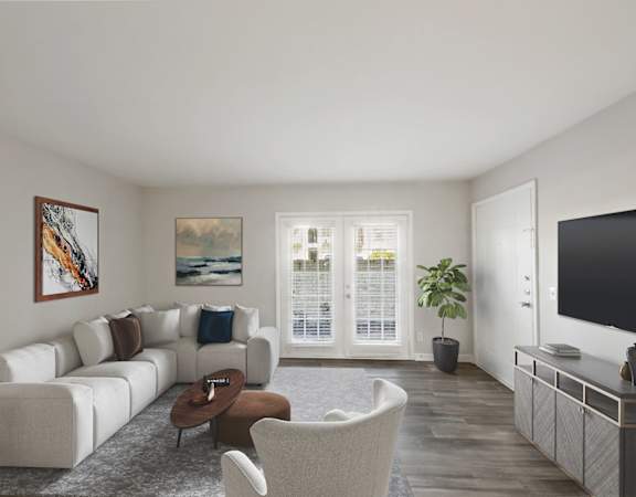 A living room with a white couch, a brown coffee table, and a painting on the wall.
