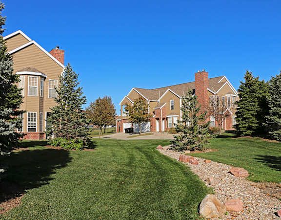 Villas buildings with a well-manicured lawn and a clear blue sky.