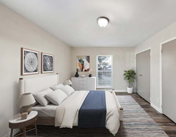 Apartments in Sandy Springs Georgia for Rent – Celebration at Sandy Springs - A bedroom with a bed, nightstand, and a plant.