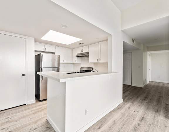A kitchen with white cabinets and a white island.