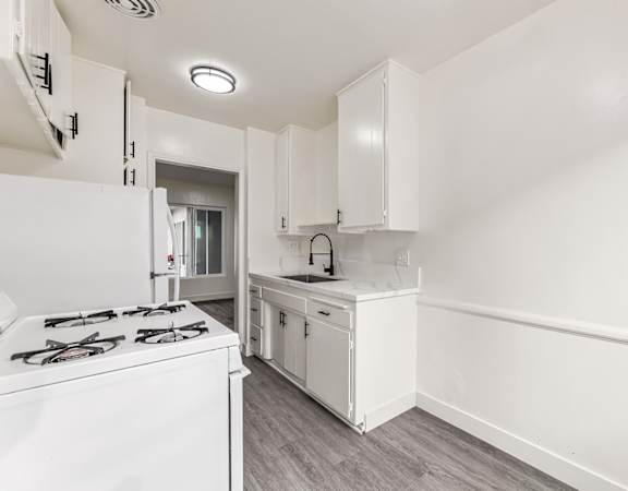 A white kitchen with a stove and cabinets.