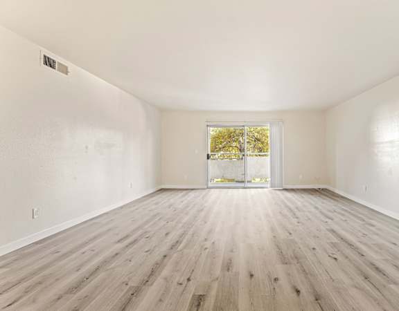 A room with wooden flooring and a window.