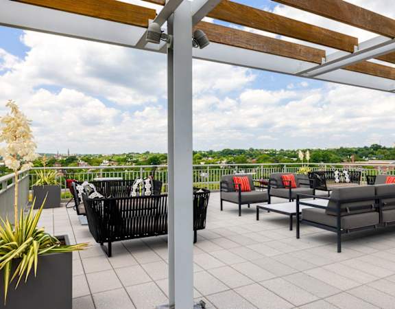 a roof deck with lounge furniture and a view of the city