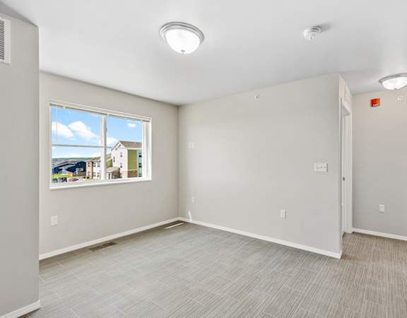 the living room and dining room of an empty home with a window