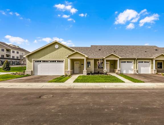 a house with two garage doors and a street in front of it