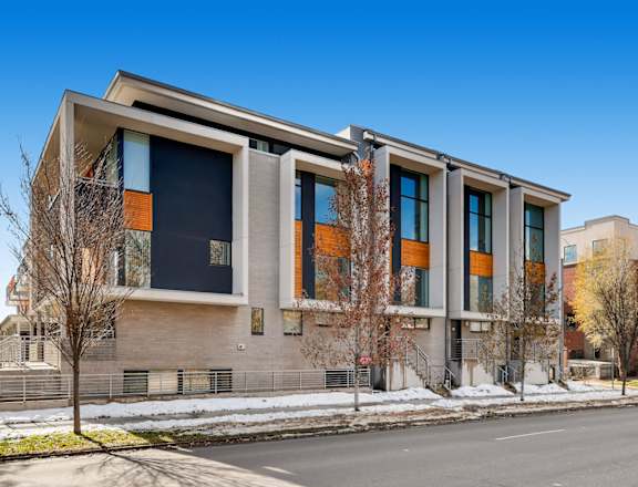 A modern building with a combination of grey and orange panels.