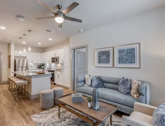 A modern living room with a grey couch and a wooden coffee table.