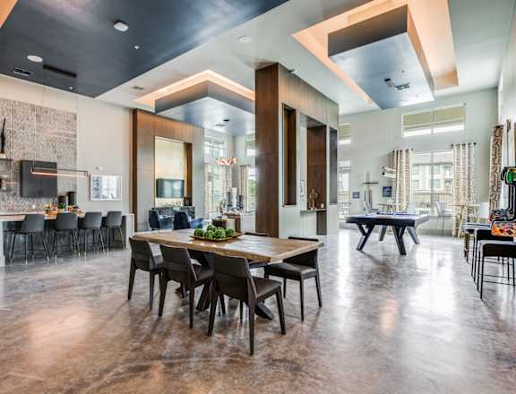 A modern dining room with a large wooden table and chairs.