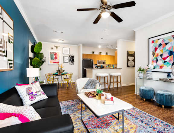 A living room with a black couch and a white coffee table.