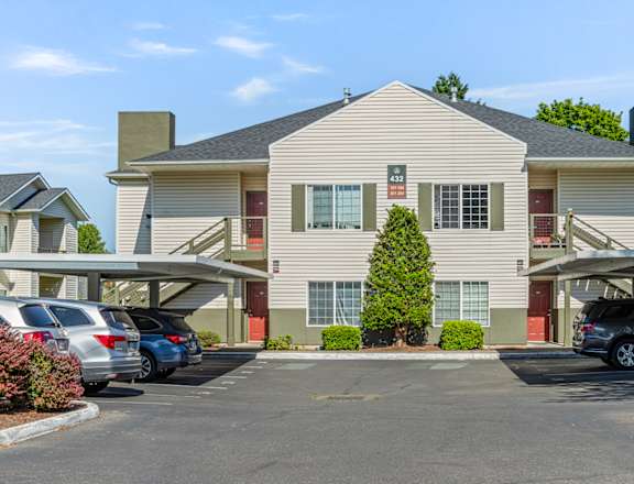 A large two-story building with a parking lot in front.