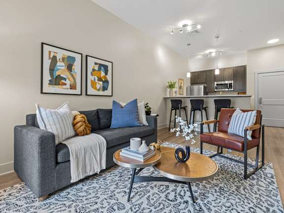 A spacious living room with a large grey sofa and a coffee table.