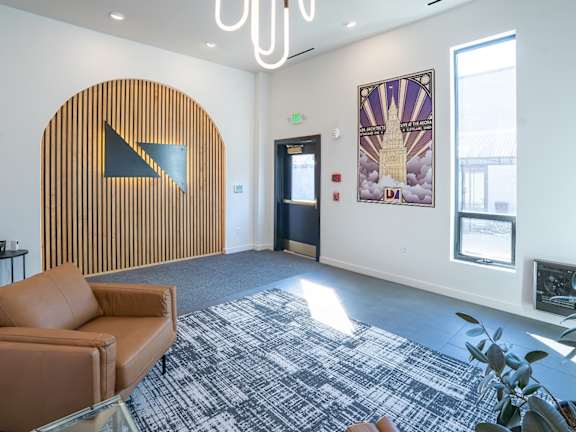 A room with a brown couch and a wooden wall with a triangle on it. at Life At Agora Apartments, Cleveland, Ohio