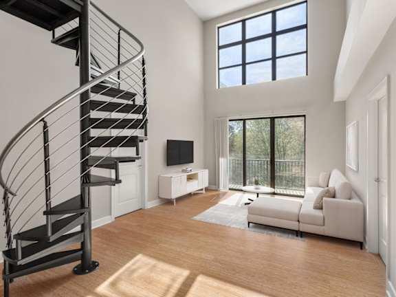 A living room with a spiral staircase and a couch.