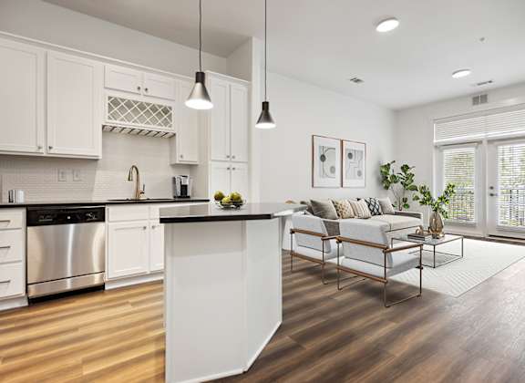 A modern kitchen with white cabinets and a wooden island.