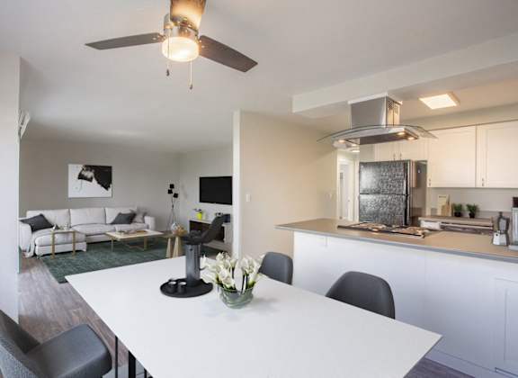 a living room with a white table and a kitchen