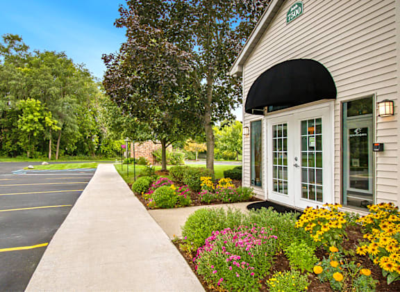 the front of a building with a flower garden in front of it