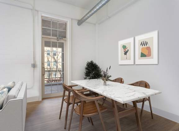 A dining room with a white table and chairs.