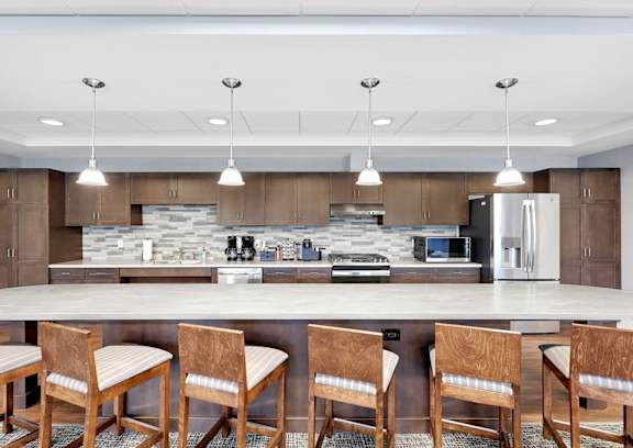 a kitchen with a large island with chairs and a counter