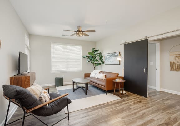 a living room with a couch and a chair and a ceiling fan
