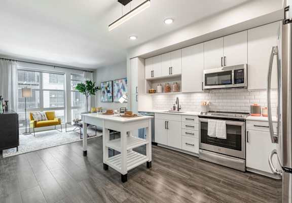 a kitchen with white cabinets and stainless steel appliances at Coda at Bryant Street, Washington, DC 20002