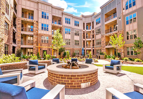 an outdoor courtyard with a fire pit and lounge chairs at Artesia Big Creek, Alpharetta, GA