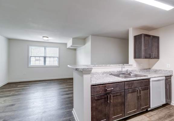 A kitchen with dark wood cabinets and a white countertop.