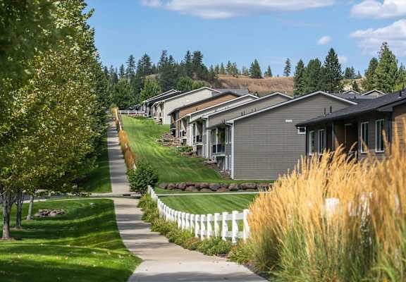 A row of houses with a white picket fence in front.