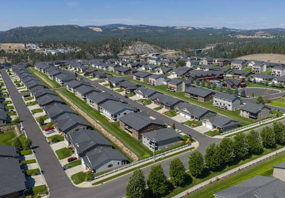 A suburban neighborhood with houses and a mountain in the background.