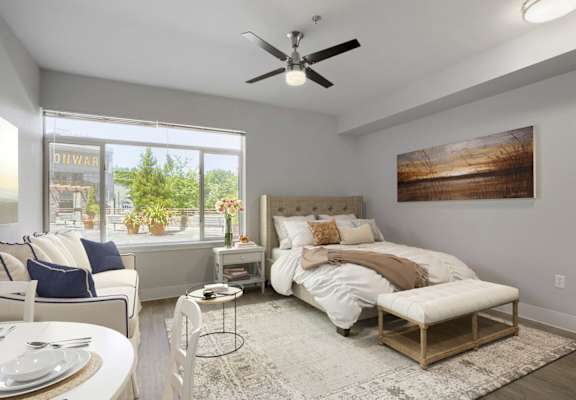 A bedroom with a large bed, a chair, and a dining table.