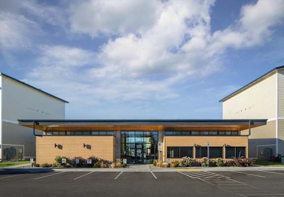 the front of a building with a parking lot