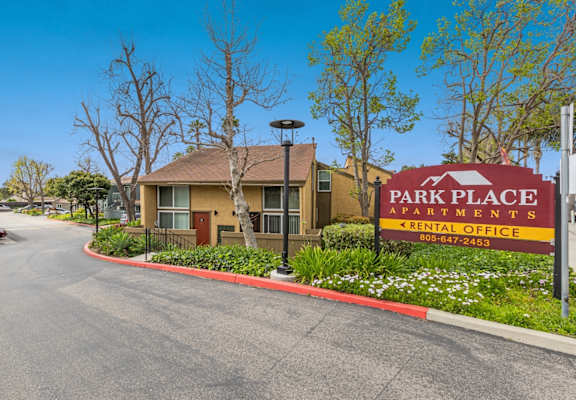 A sign for Park Place Apartments is in front of a building.