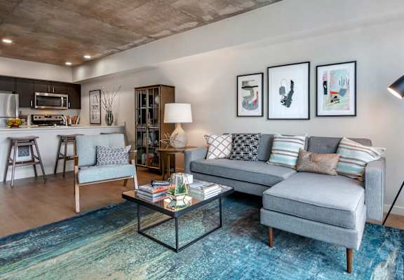 A modern living room with a grey sofa and a coffee table.