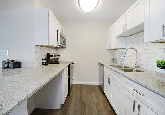 a kitchen with white cabinets and white countertops